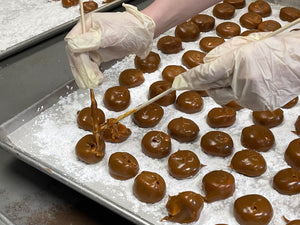 placing caramallow kisses onto a tray of sugar