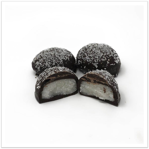 Dark chocolate coconut cream cut in half in front of two other coconut creams