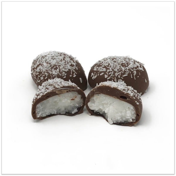 Milk chocolate coconut cream cut in half in front of two other coconut creams