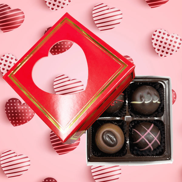 Four pieces of assorted truffles inside red box with heart shaped window.