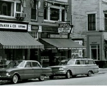 Picture of the downtown storefront showing the sign and cars out front